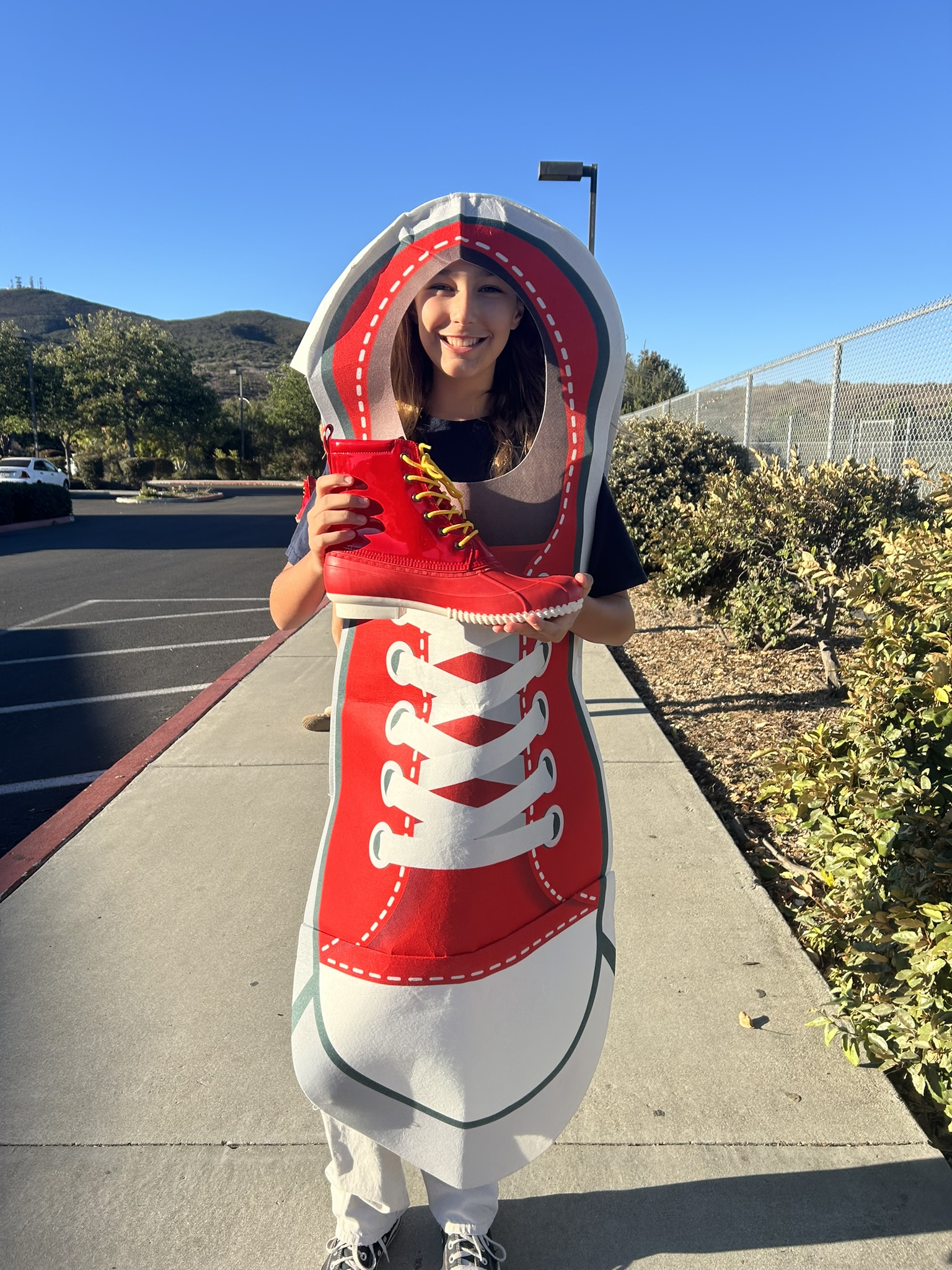 Girld dressed in a red shoe costume holding a red boot