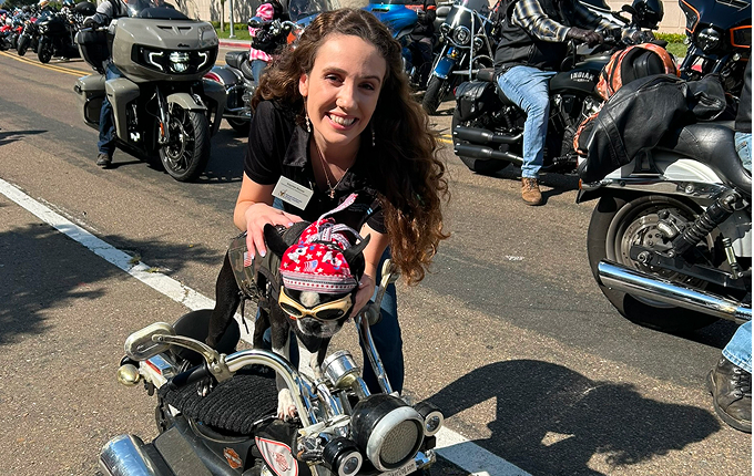 Girl and dog riding a motorcycle