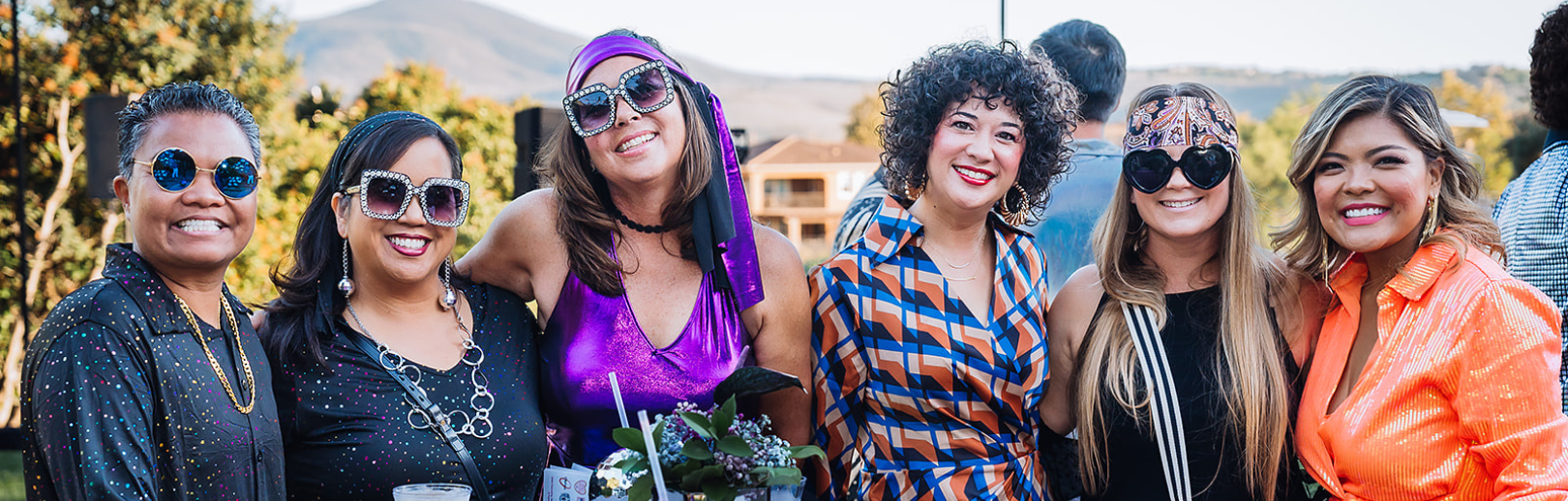 Group of smiling women dressed in disco type clothes