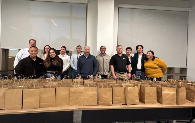 Group smiling in front of bags
