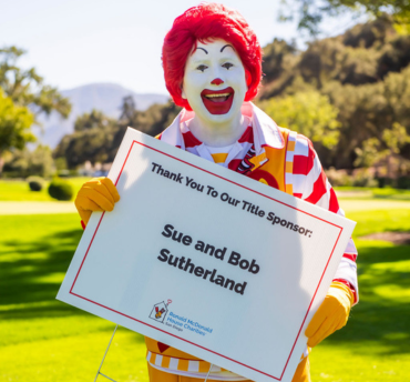 Ronald holding a sign thanking Sue and Bob Sutherland for being a title sponsor