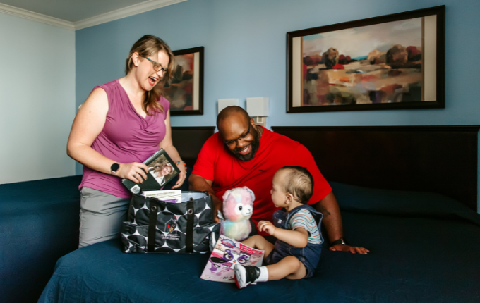 mom dad and child looking at items in a welcome bag