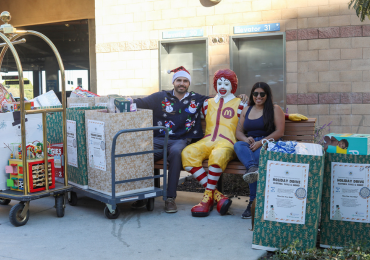 Two volunteers sitting with donations