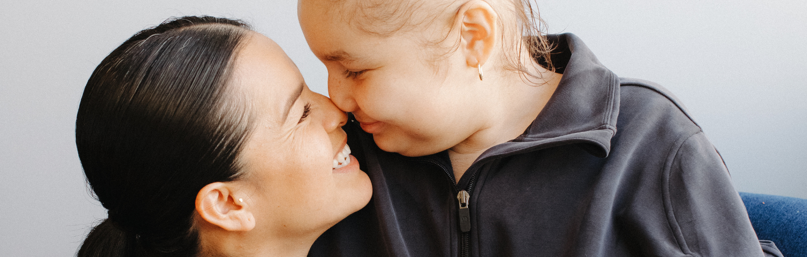 Mom and daughter face to face smiling
